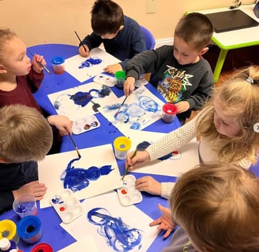 Children painting with guidance at Kids Land Daycare, Warminster