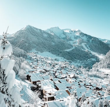 a snowy mountain scene with a view of a village