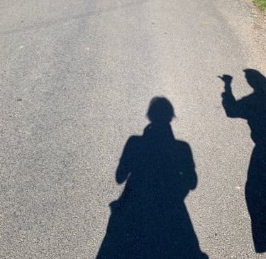 two people standing on a street with their hands up to their backs