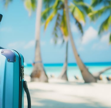 Blue suitcase on tropical beach with palm trees, perfect for Dominican Republic packing list