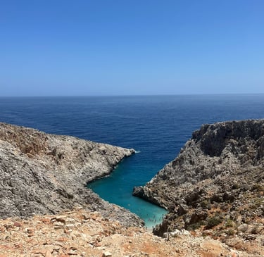a person standing on a rocky cliff overlooking the ocean