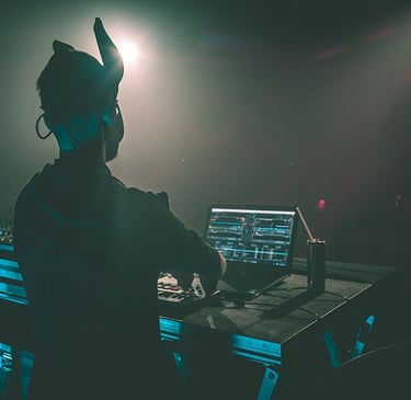 Vue immersive d’un DJ en pleine performance sous des faisceaux colorés, saisie en photo et vidéo par Thomas Bordas.