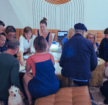 a bootcamp cohort sitting around a table working on an exercise