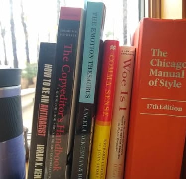 Coffee cup and windowsill of books about writing and editing