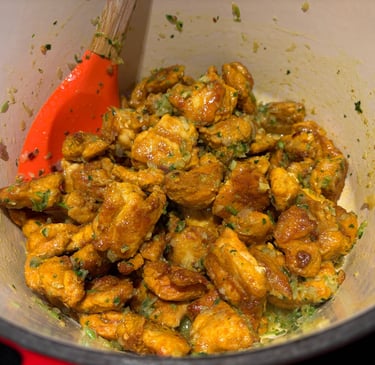 cooked chicken thigh pieces mixed with the aromatic flavour base in pot