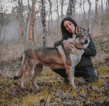 donna con lupo cecoslovacco nel bosco