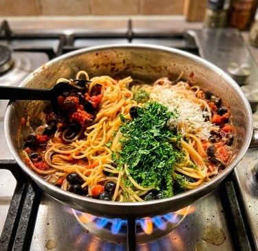 Spaghetti puttanesca with olives and capers topped with fresh parsley and cheese in a pan.