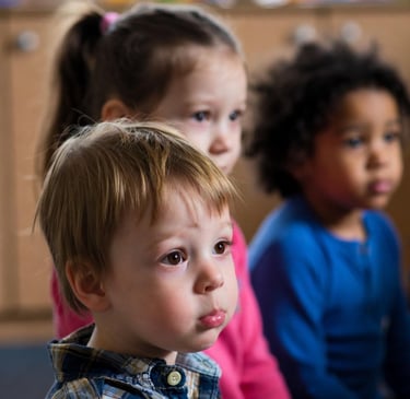 A boy with selective mutism sits with peers for carpet time in a UK nursery.