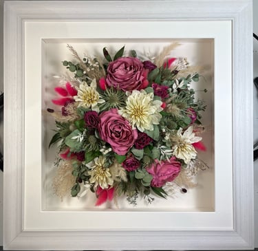 a Birdseye view Style bouquet of flowers in a rustic white frame