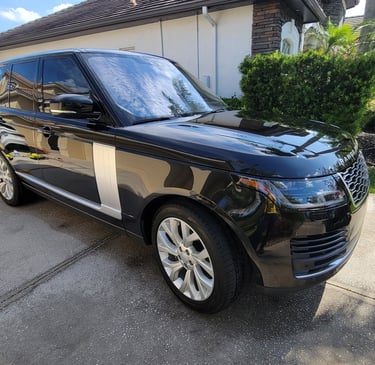 A black Ranger rover SUV ina tampa bay drive way surrounded by mobile detailing equipment