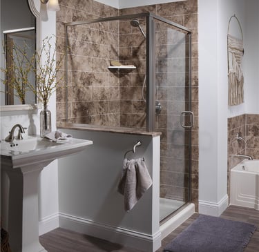 Modern bathroom with corner glass shower, stone tile walls, and pedestal sink