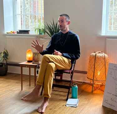 a male meditation teacher sitting in a chair