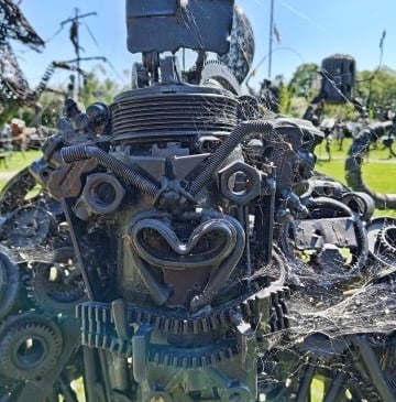 A detailed scrap metal gorilla sculpture made from recycled gears, bolts, and industrial parts.