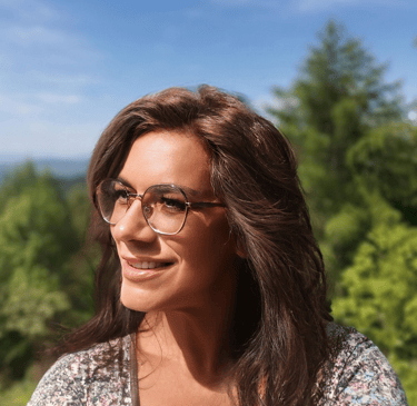 a woman with glasses and a floral top