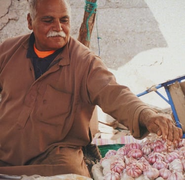 man in brown jacket selling spices in souk