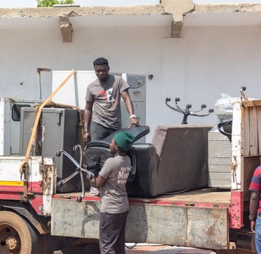 Three professional movers from TE Transporter Express load household appliances and furniture—includ