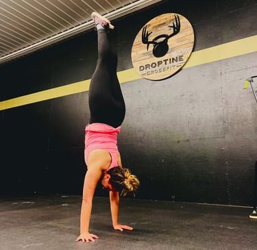 a woman doing a handstand on a gym floor
