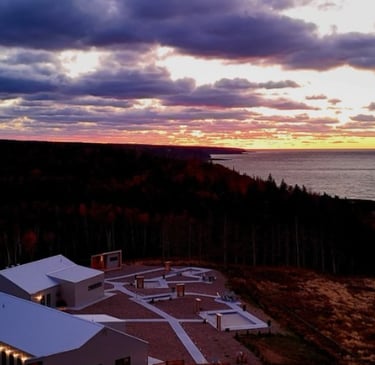 Aerial view of a Saltair Nordic Spa & Wellness during dramatic sunset over the ocean.
