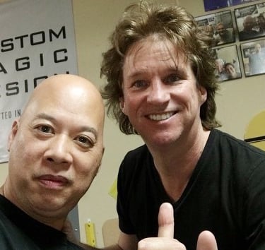 Ray and Greg Gleason smiling for a selfie at a custom magic design studio.