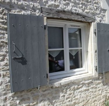 Des volet en bois gris avec une peinture naturelle moins chère à l'achat et en simple en entretien