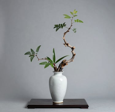 A sleek, modern vase with a smooth matte finish sitting on a wooden shelf against a soft neutral wall.