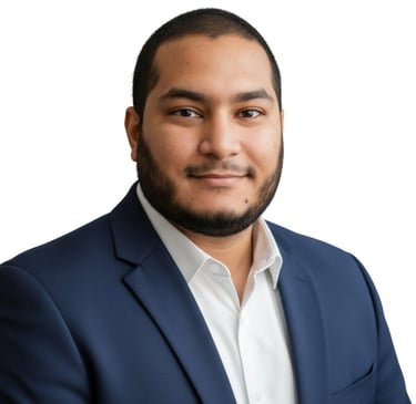 Professional headshot of a smiling man with a beard wearing a navy blue suit and white shirt.