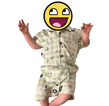 Picture of a baby with a smiley face emoji covering his face