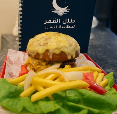 همبرغر مع بطاطس مقلية وكتاب قائمة طعام ظلال القمر وسلوجان لحظات لا تُنسى