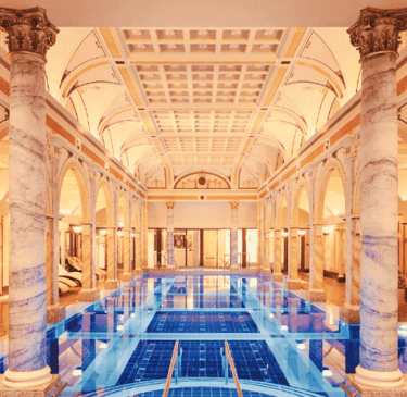 a large luxury indoor swimming pool with a blue tiles