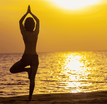 a person doing yoga on the beach