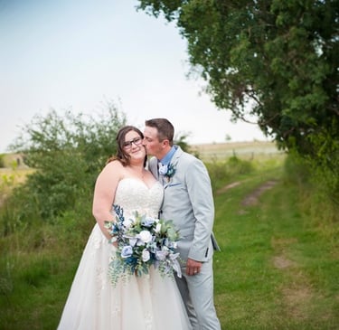 a bride and groom kissing in a field
