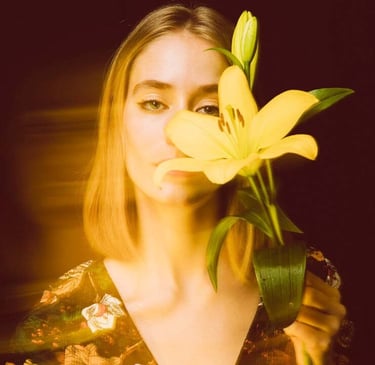 a woman holding a flower in front of a mirror