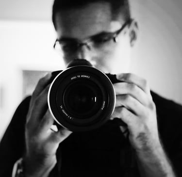 Autoportrait du photographe avec l'appareil photo au premier plan.