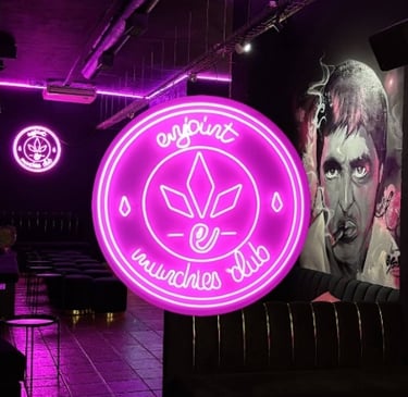 Logotipo Enjoint Munchies Club en neón rosa con diseño de hoja de cannabis y ambiente urbano