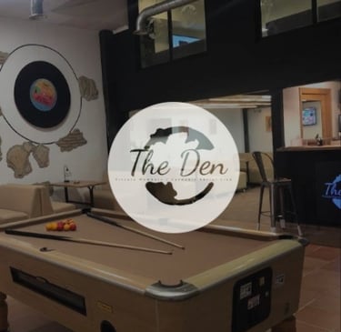 Interior de The Den Cannabis Club con mesa de billar y logotipo