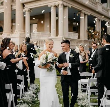 Bride and groom walking through a shower of rose petals