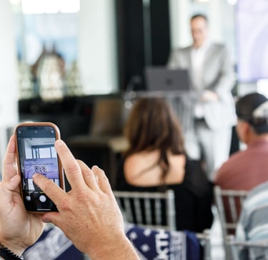 a man is taking a photo of a speaker at a business meeting