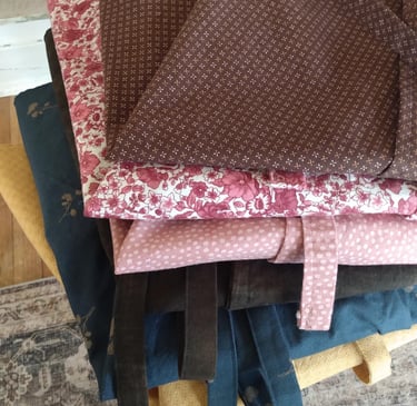A stack of neatly folded wrap skirts made with love from assorted pretty cotton calico fabrics