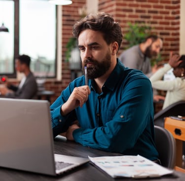 a man sitting at a desk with a laptop computer