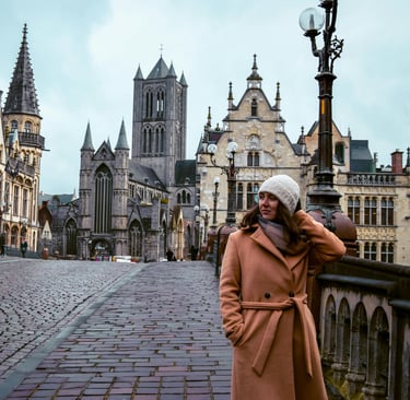 A woman in coat leaning on the wall in Ghent