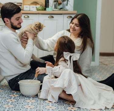 family relaxing together on the sofa in a bright, tidy living room with soft light