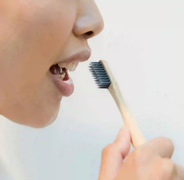 a woman in a bathrobear with a toothbrush in her mouth
