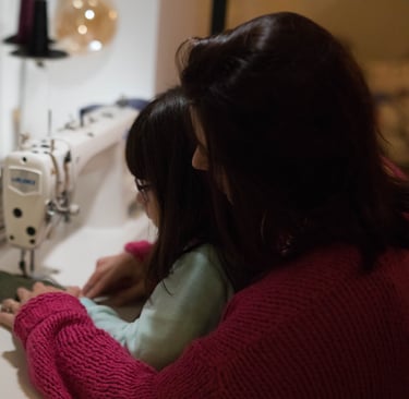 une femme et une petite fille sont en train de coudre un sac banane