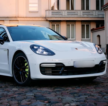 an Enlab white porsche panamera parked in front of a building