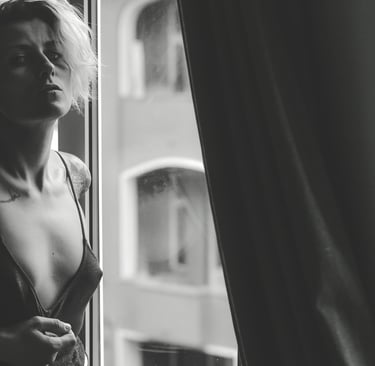 a woman in a lingersuit sitting on a window sill posing for a photo