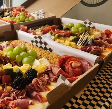 a variety of food, cheese, fruit and crackers in boxes