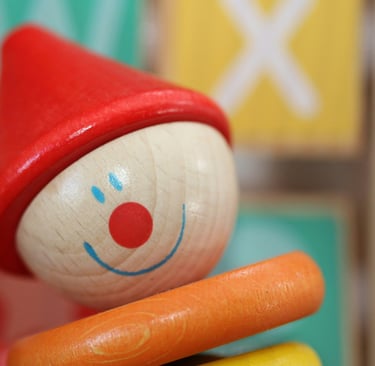 Close-up of colorful wooden clown toy with alphabet blocks, symbolizing childhood and playful learni