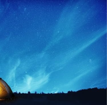 tienda de campaña frente a un cielo estrellado