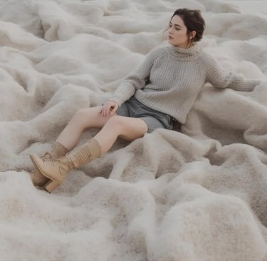 a woman sitting on a pile of white furnishes