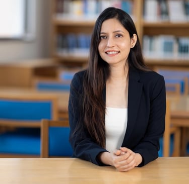 Dr Anam in black suit in library